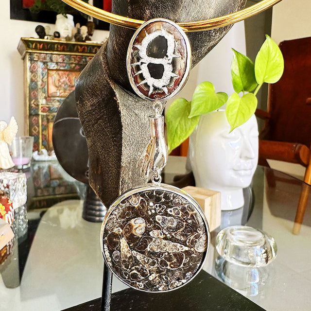 Dije de mano con piedras y fósiles
